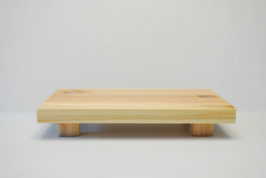 Handmade rectangular cedar display stand with minimalist design, featuring a smooth natural wood surface and short cylindrical legs, ideal for showcasing plants, candles, or decor.