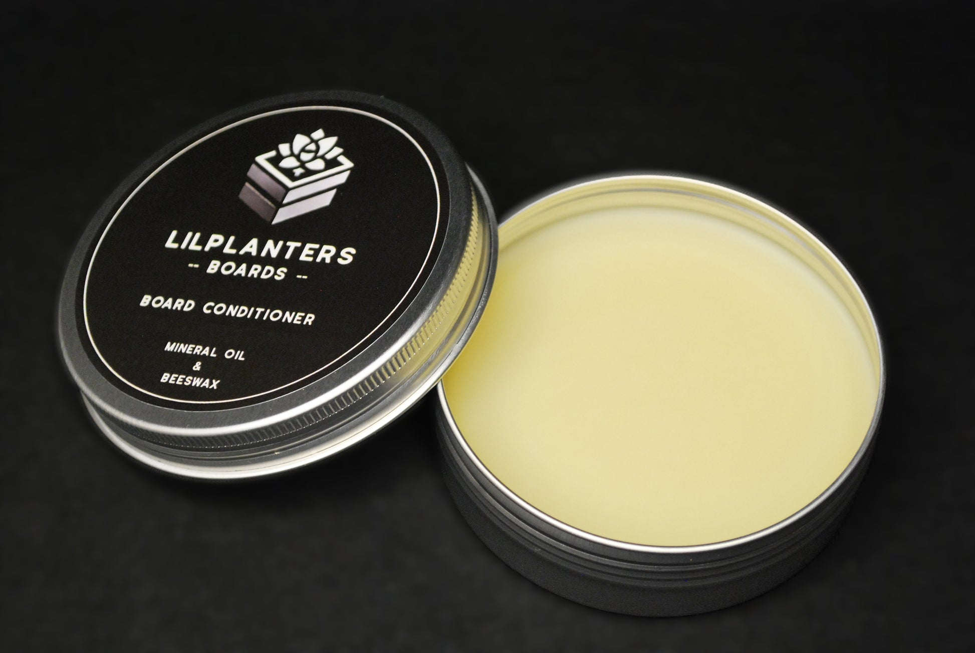 lilplanters board conditioner in a tin on a black background