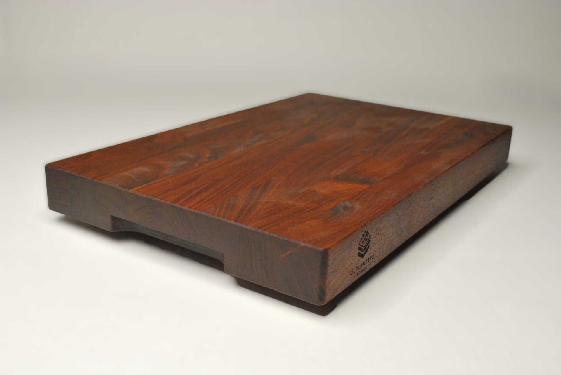 Solid walnut cutting board on a white background