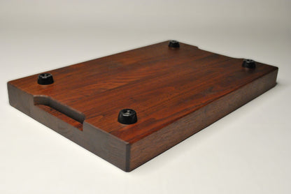 Solid walnut cutting board on a white background