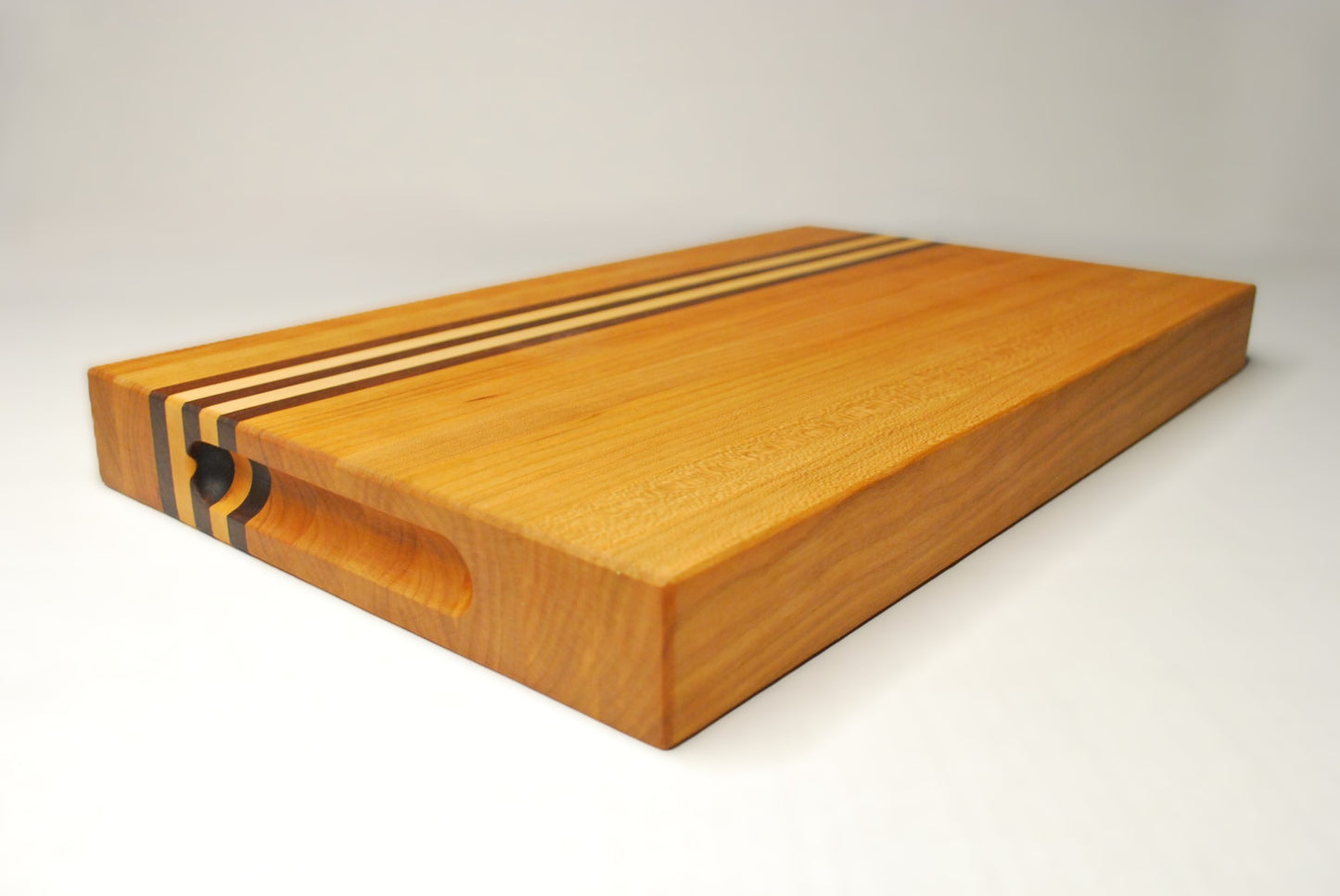 Wooden cutting board with a striped design on a white background