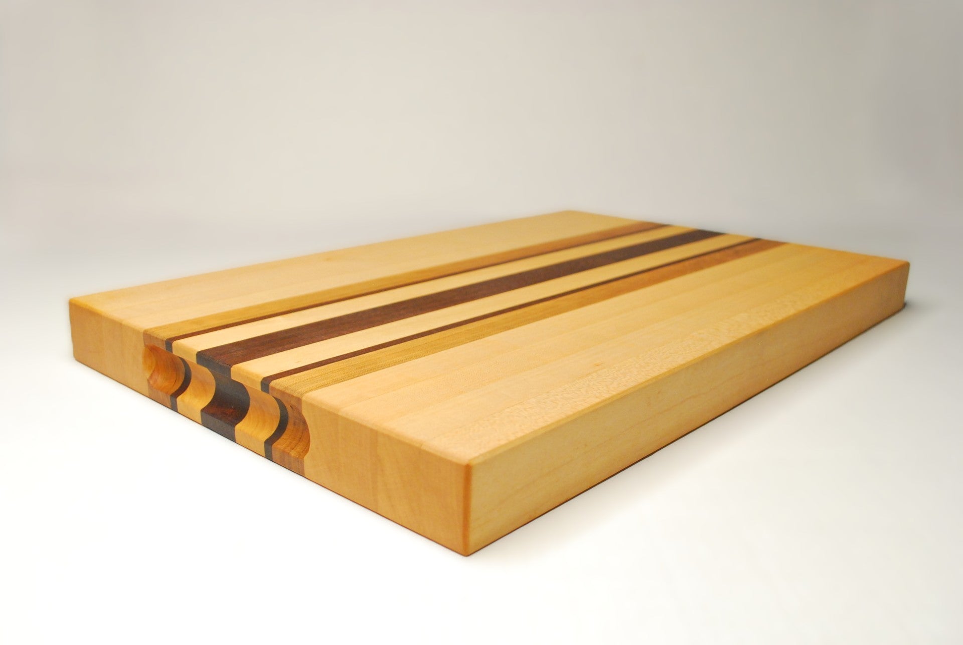 Wooden cutting board with a dark brown stripe on a light gray background
