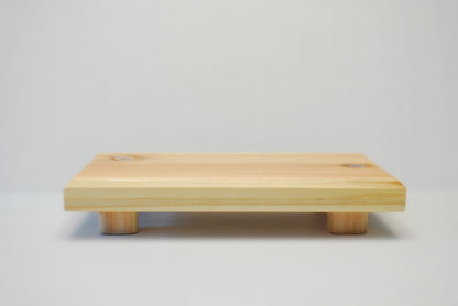 Handmade rectangular cedar display stand with minimalist design, featuring a smooth natural wood surface and short cylindrical legs, ideal for showcasing plants, candles, or decor.