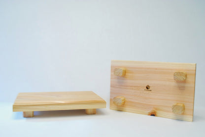 Handmade rectangular cedar display stand with minimalist design, featuring a smooth natural wood surface and short cylindrical legs, ideal for showcasing plants, candles, or decor.