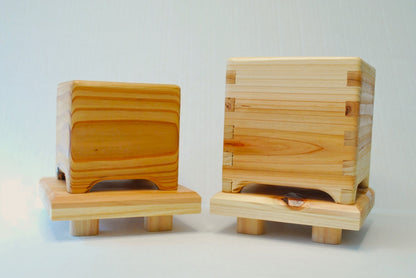 Handmade square cedar display stand with minimalist design, featuring a smooth natural wood surface and short cylindrical legs, ideal for showcasing plants, candles, or decor.